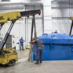 man loading blue boiler tank