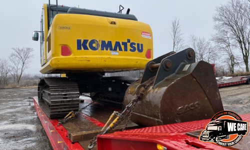 Komatsu excavator loaded for transport on lowboy trailer