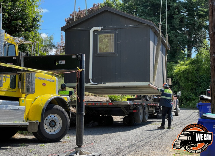 Crane loading a Shed on a trailer.